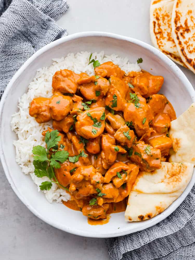Butter chicken served over white rice with naan.