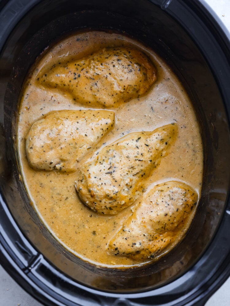 A top view of chicken and gravy in a crockpot. 