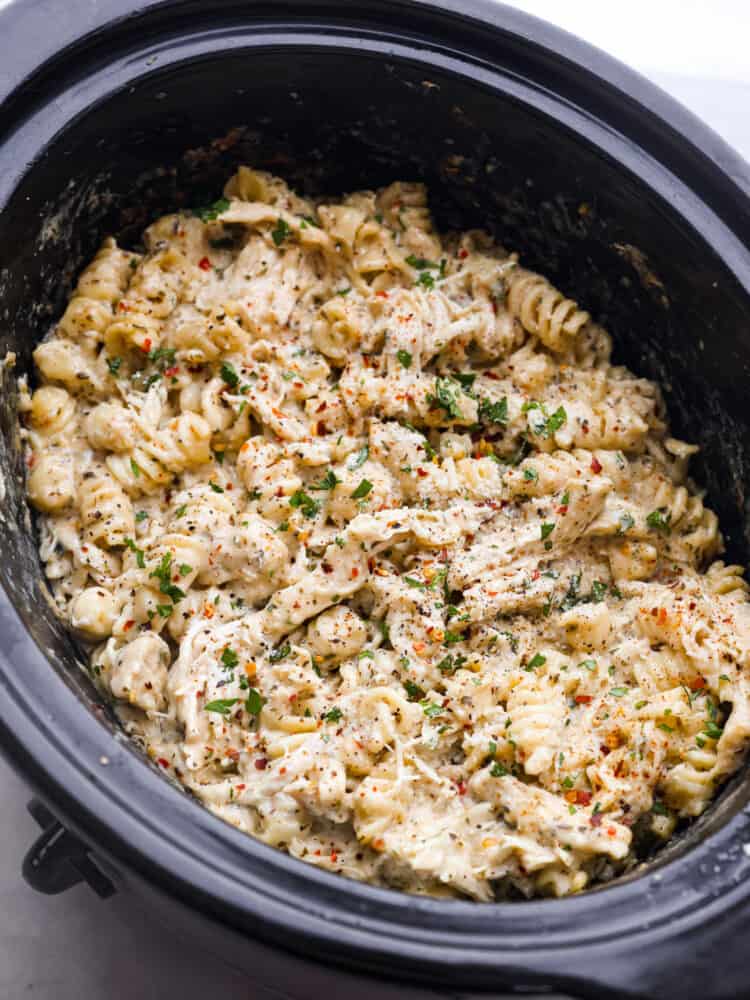 Cooked parmesan garlic chicken pasta in a crockpot.