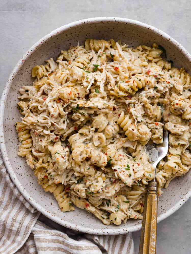 A serving of chicken pasta in a gray speckled bowl.