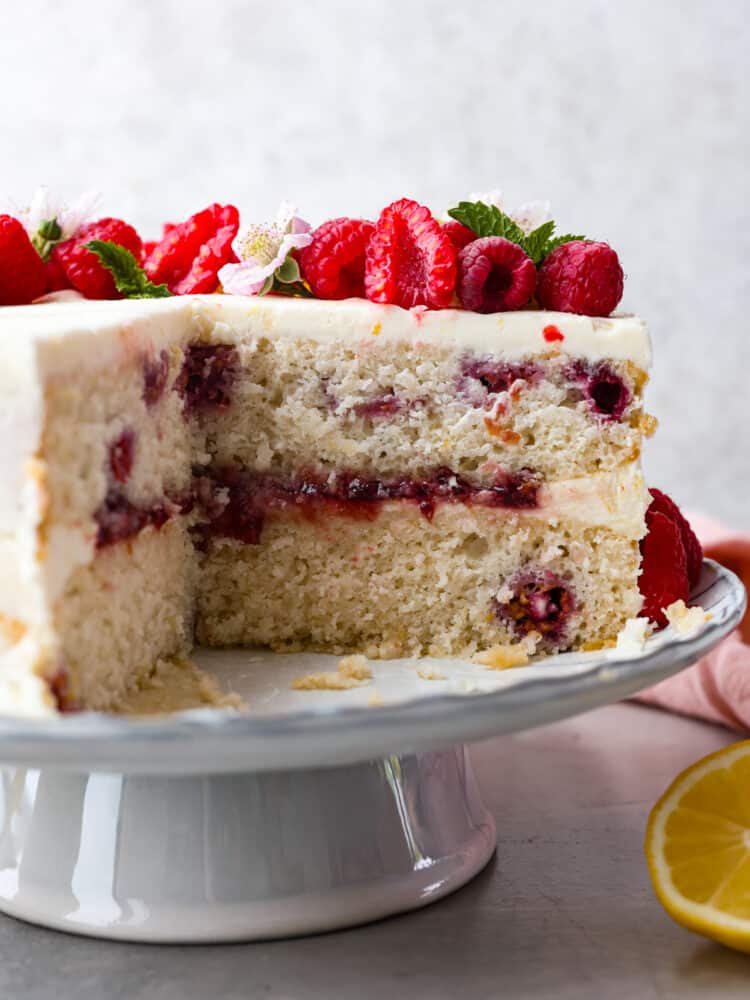 Lemon raspberry cake with a slice taken out of it.