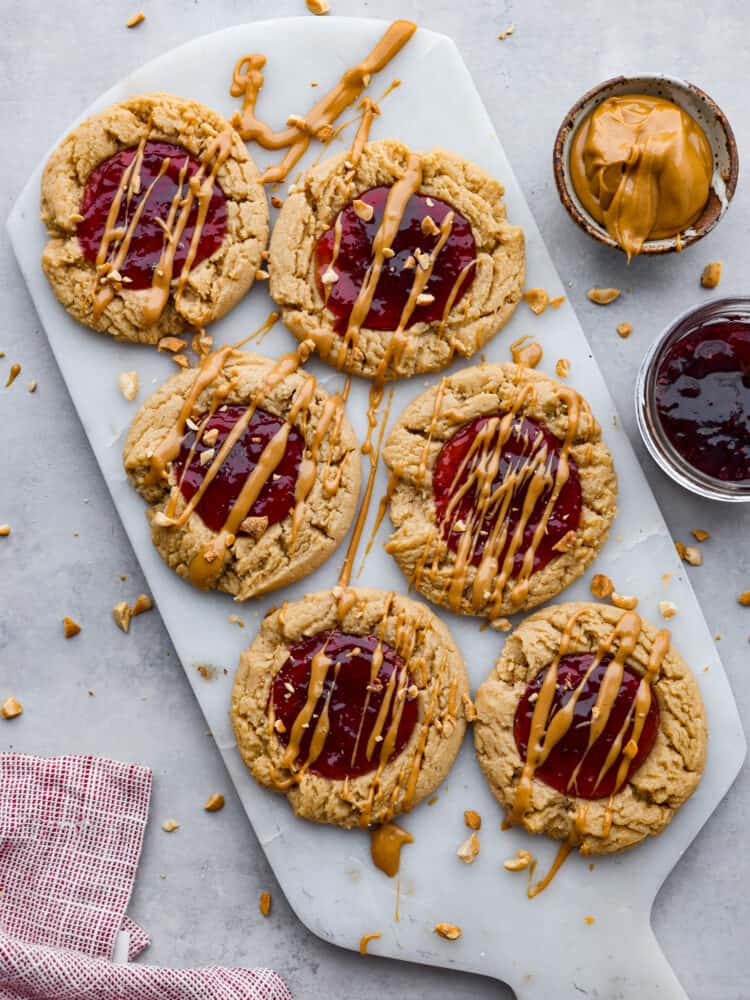 6 peanut butter and jelly cookies on a stone slab.