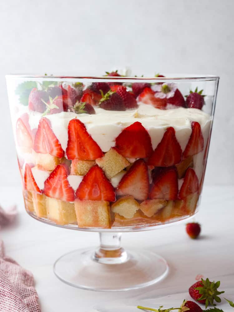 Hero image of strawberry trifle. All of the layers can be seen through the glass dish.