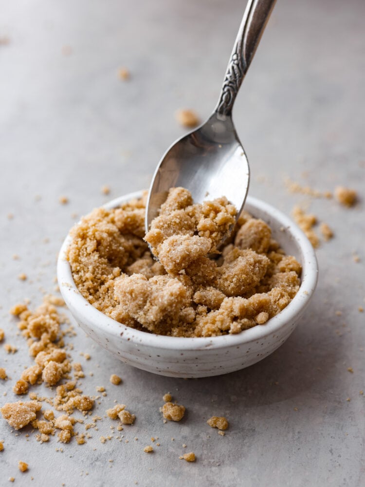 A spoon scooping out some streusel topping. 
