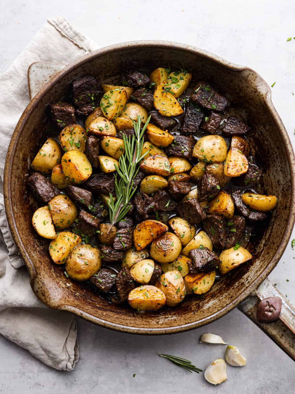 Garlic Butter Herb Steak Bites with Potatoes in a skillet. 