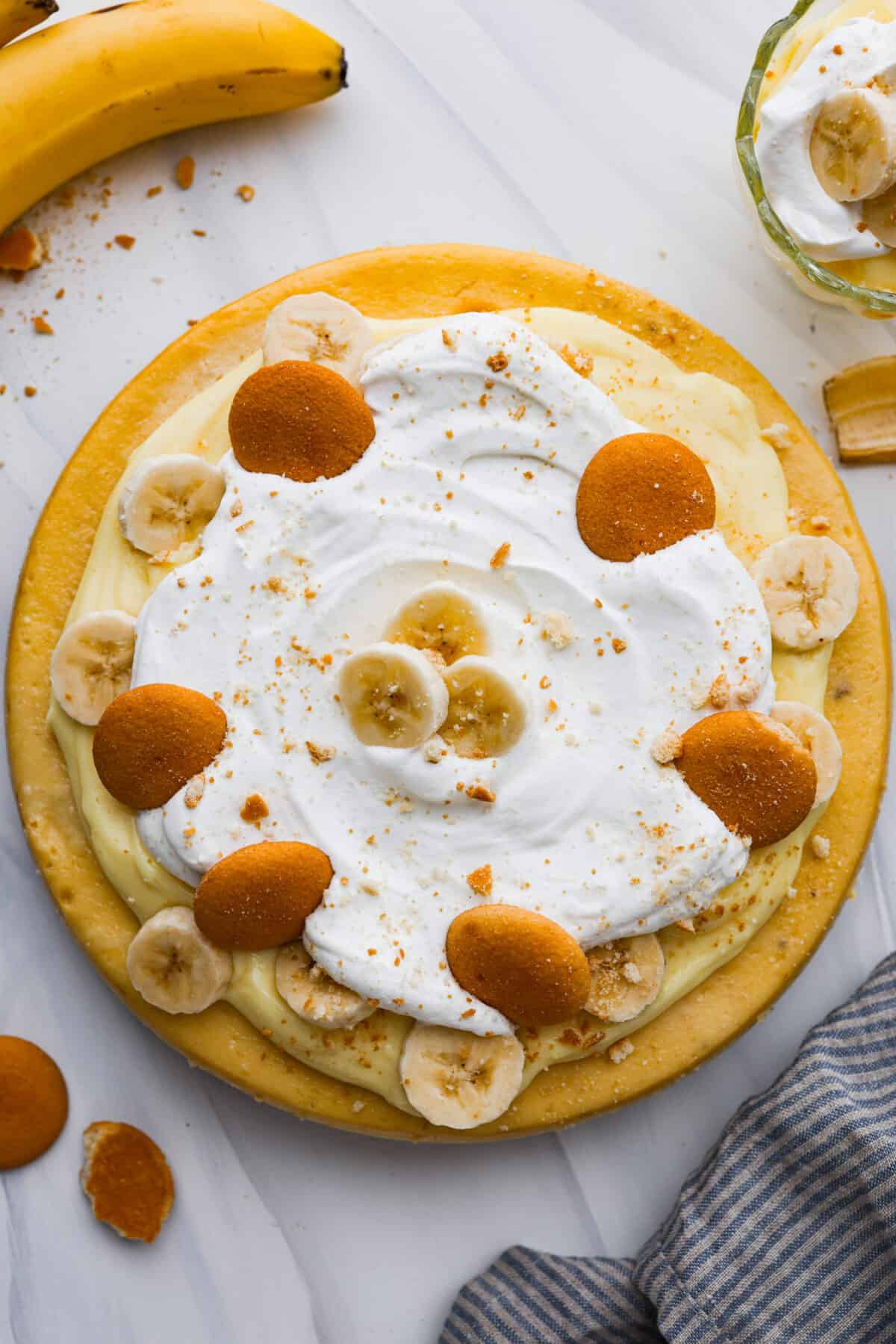 The top view of a banana pudding cheesecake that is topped with sliced bananas and Nilla wafers. 