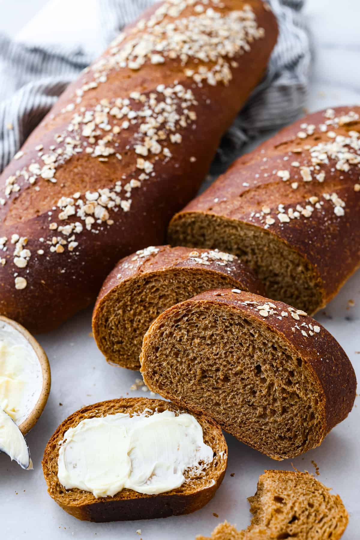 Close view of baked brown specie loves. Once loaf is sliced with butter spread onto a piece of bread.