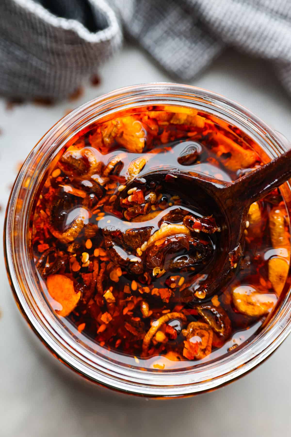 Top-down view of chili crisp oil in a glass jar.