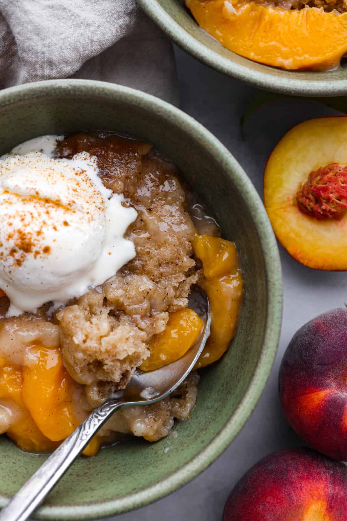 A close up of a bowl of slow cooker peach cobbler. 