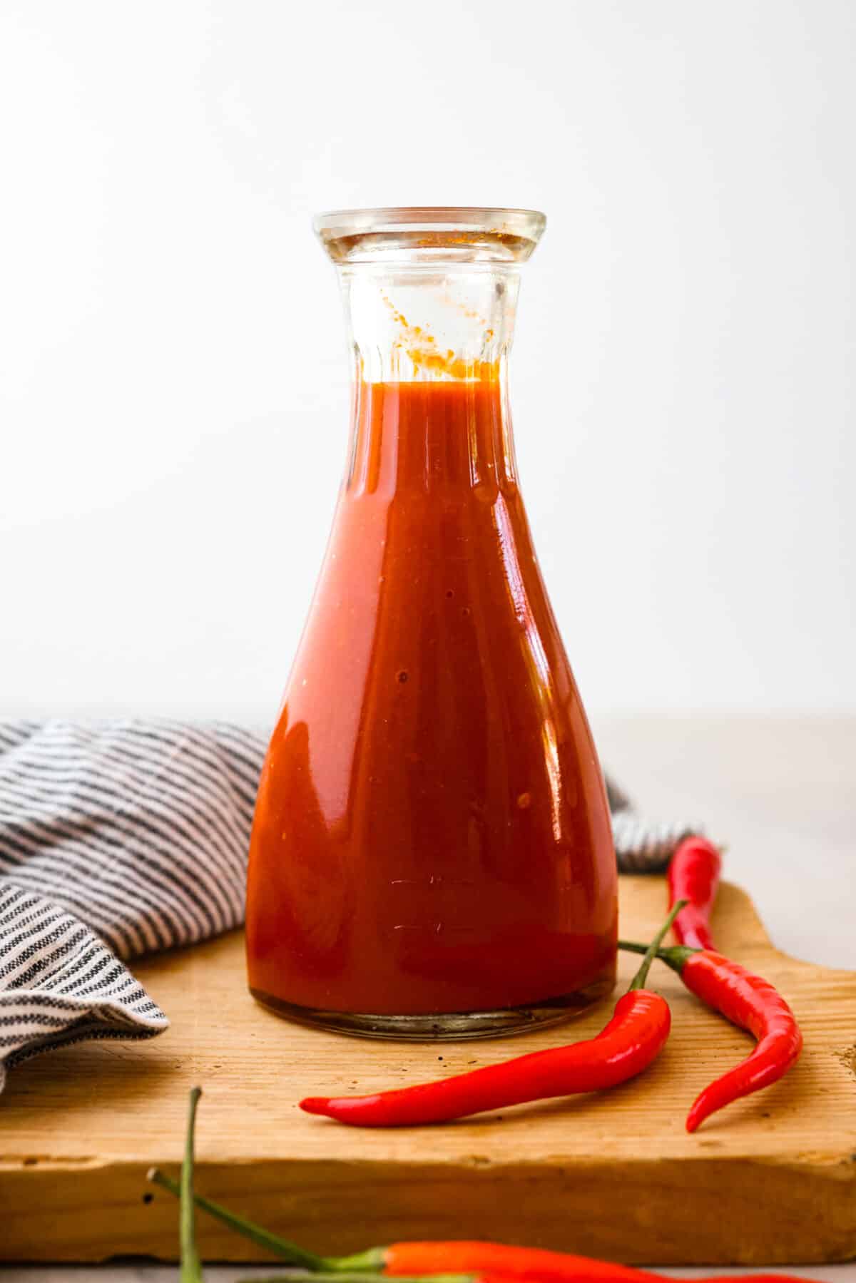 Homemade sriracha sauce in a glass bottle.
