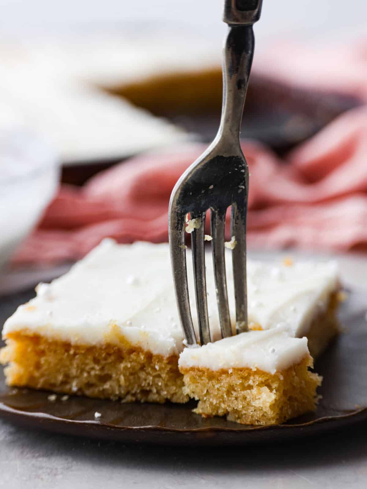 Closeup of a slice of cake, with a bite being taken out of it.