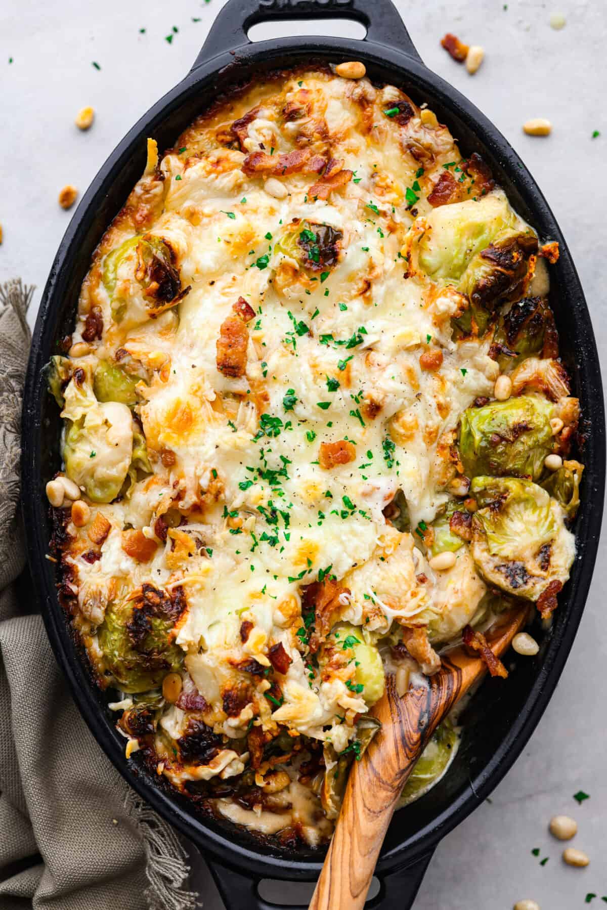 Top-down view of a cooked brussels sprout casserole in a black baking dish.