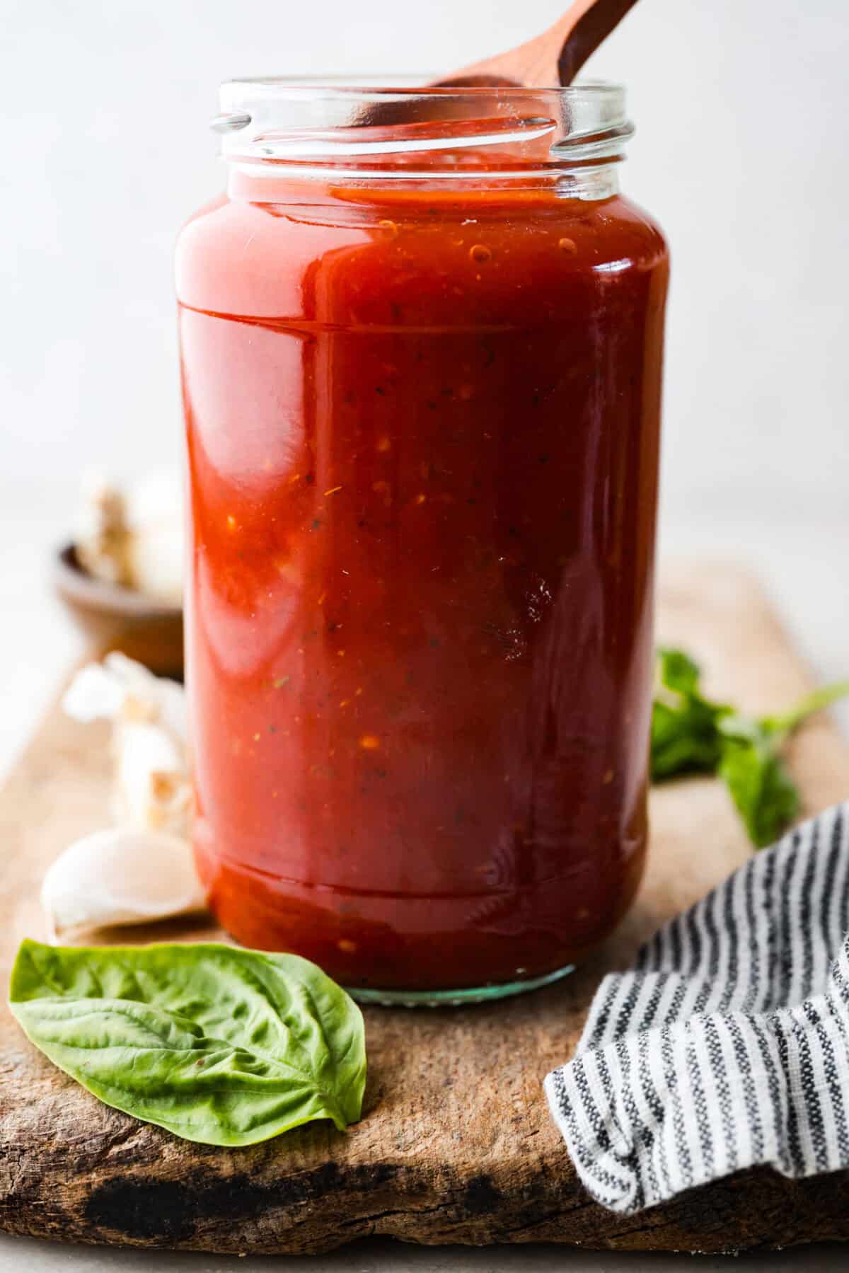 A glass jar filled with homemade marinara sauce.