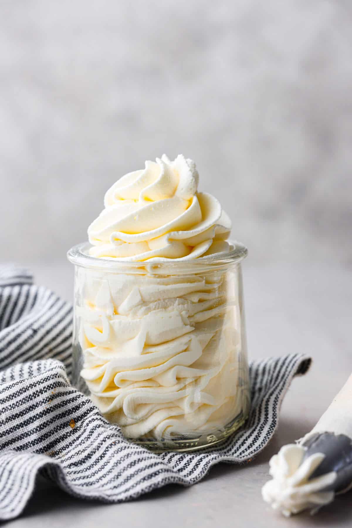 Close up view of stabilized whipped cream piped in a glass jar.