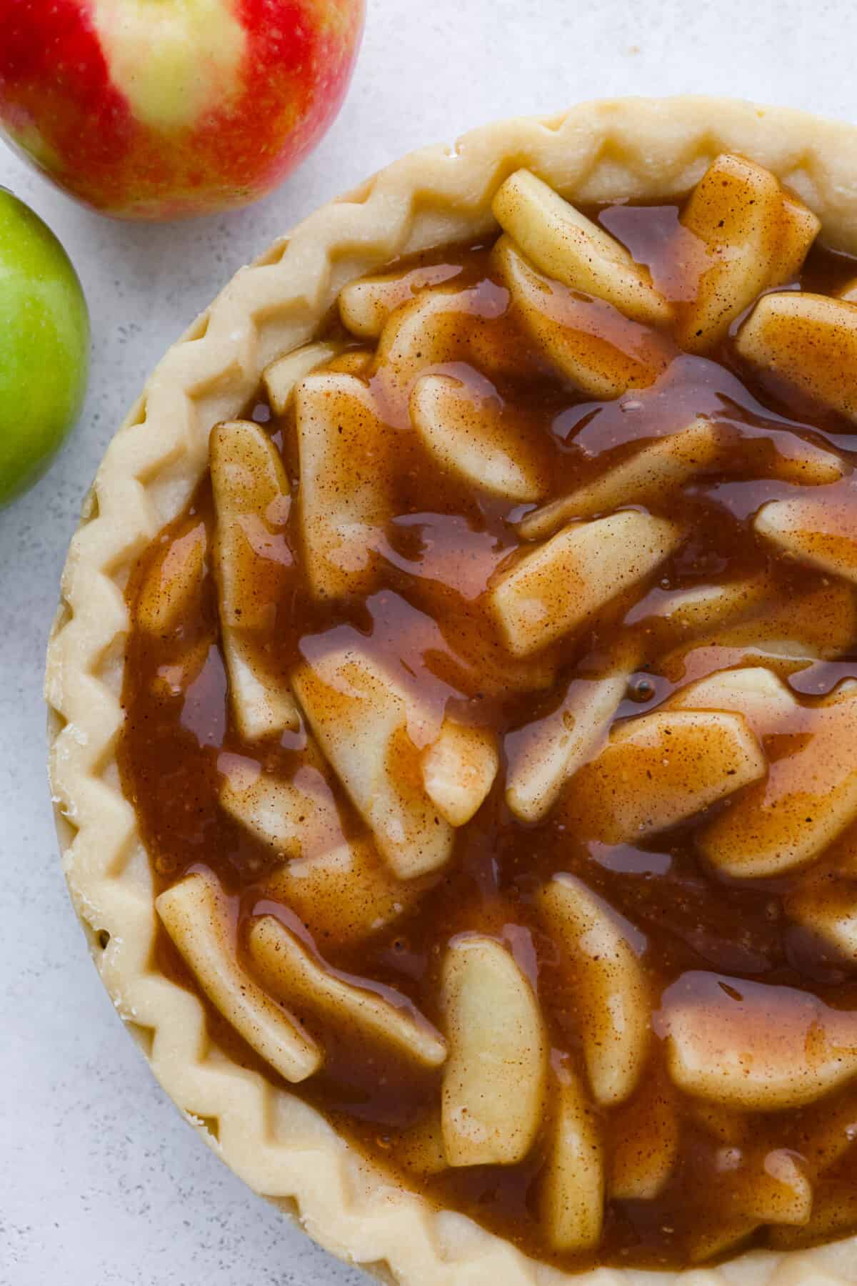Apple filling added to a pie crust.