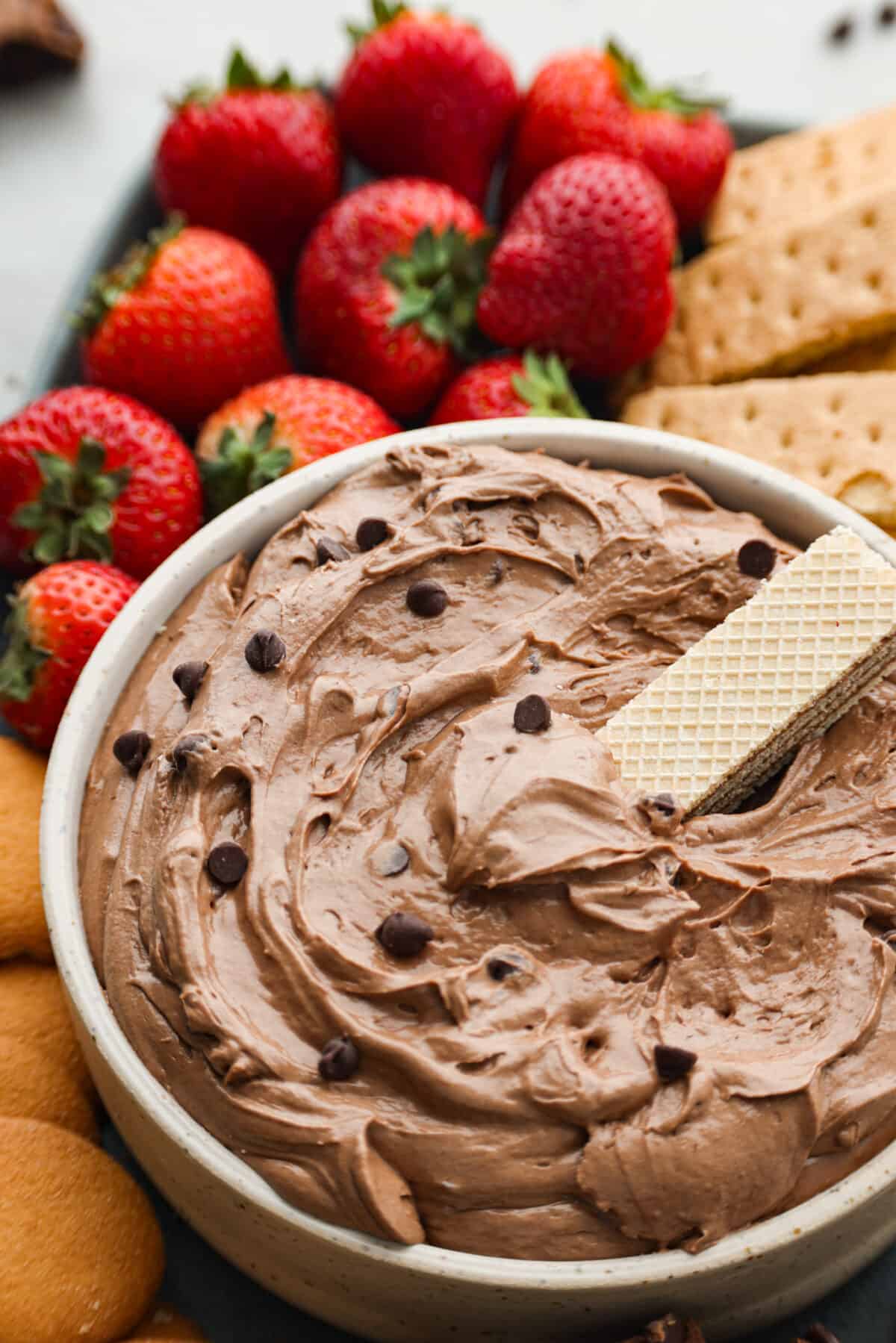 Hero image of brownie batter dip in a white bowl, served with a wafer cookie.