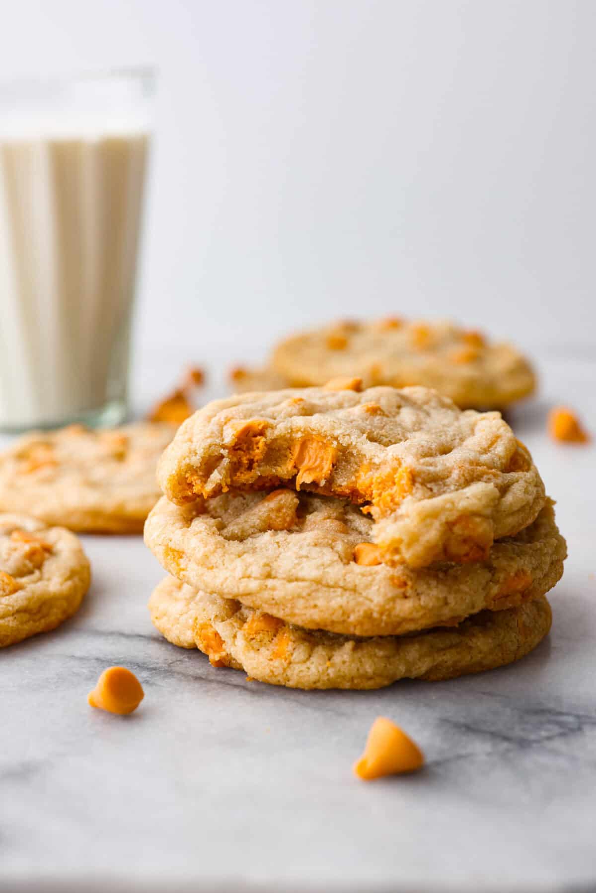 Satisfy your sweet cravings with these classic Butterscotch Cookies. Soft and chewy and packed with sweet butterscotch chips, these golden treats are easy to whip up, making them the ideal treat for any occasion. A stack of butterscotch cookies with a bite taken out of the top one.