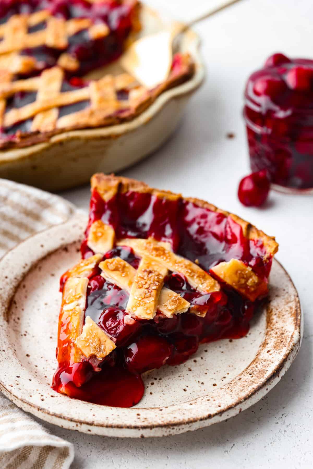 A slice of cherry pie on a stoneware plate.