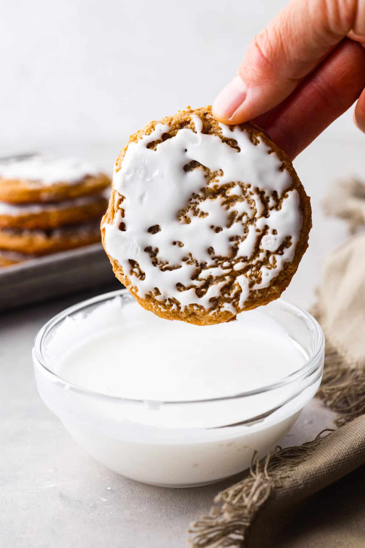 An iced oatmeal cookie, after being dipped in the glaze.