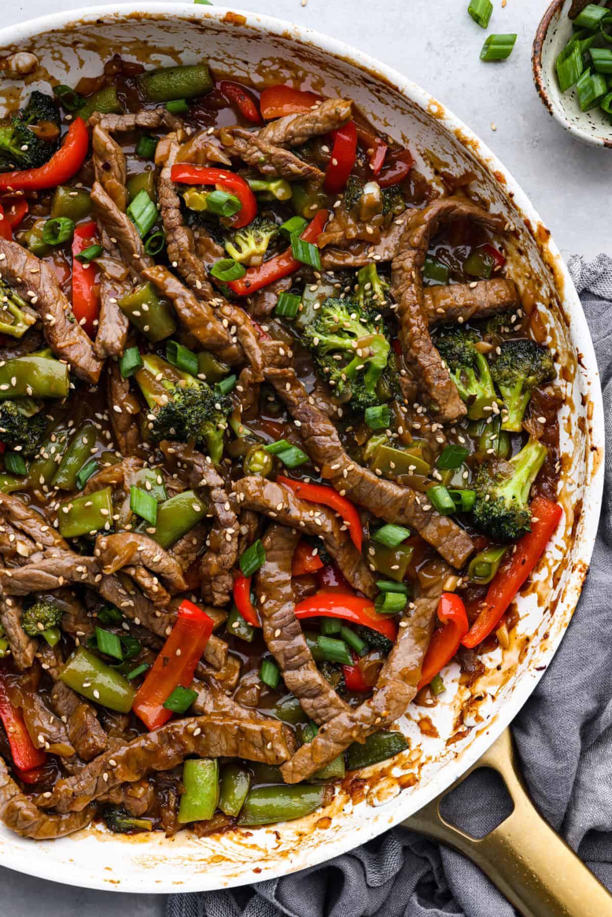 Top-down view of cooked szechuan beef in a skillet.