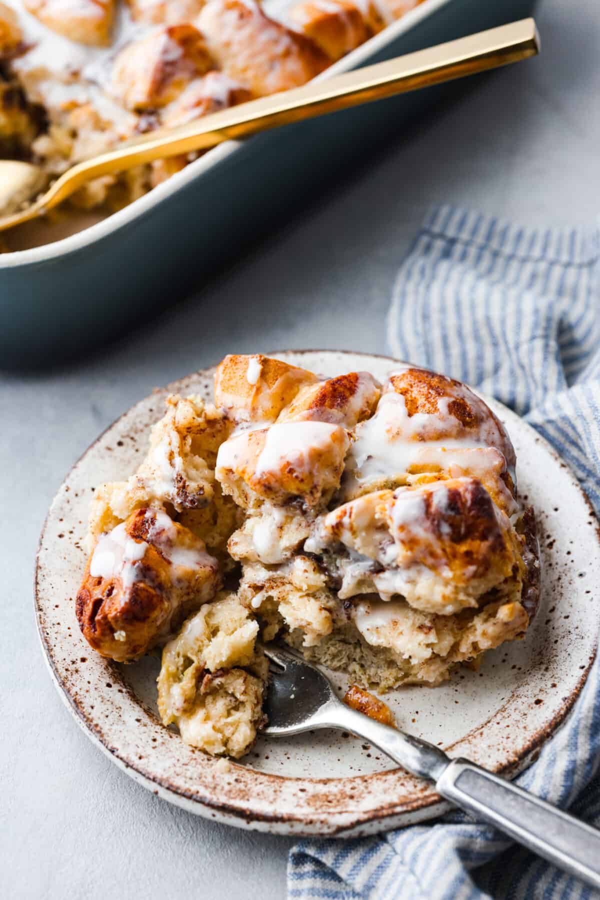 Cinnamon roll casserole on a plate with a fork. 