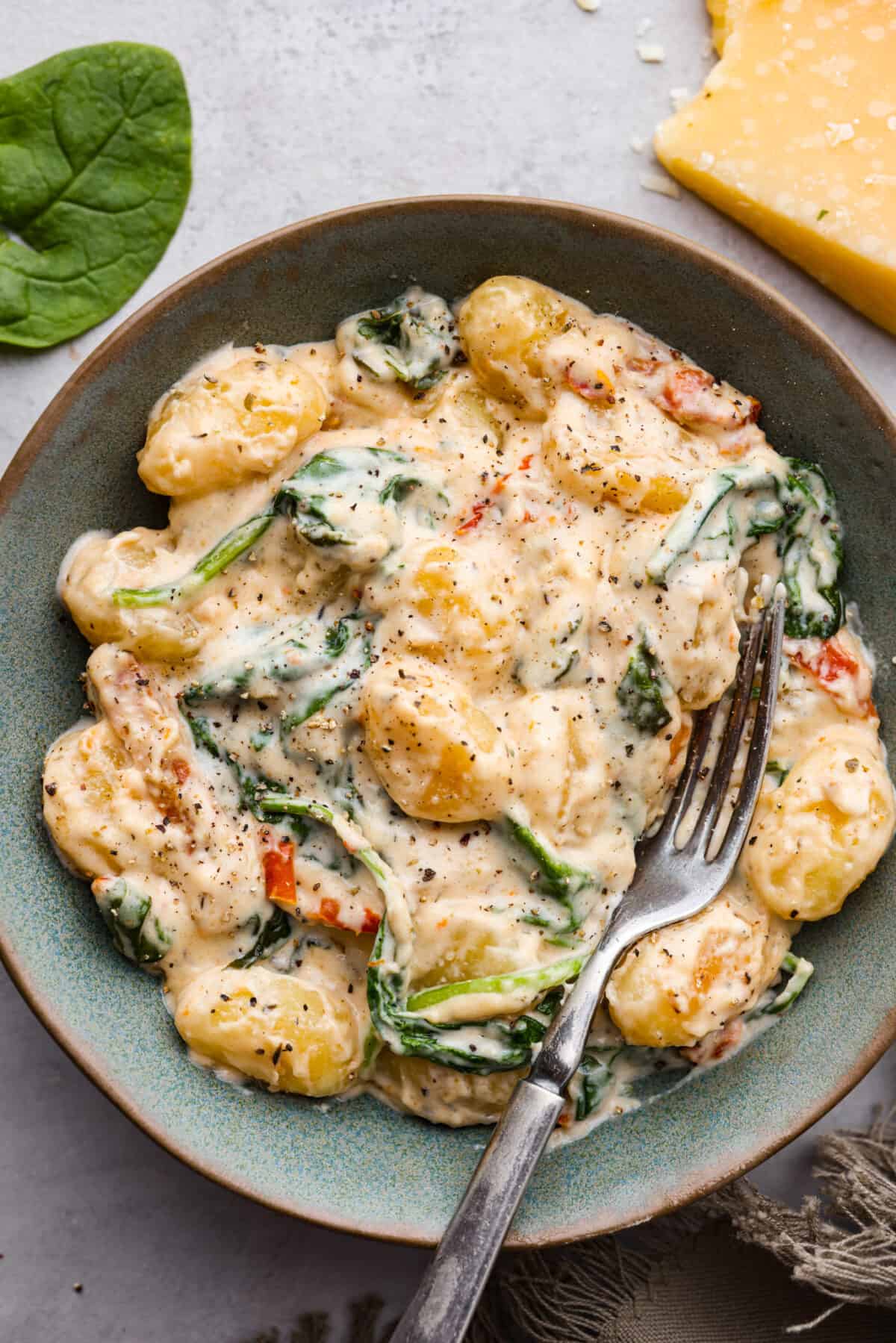 A serving of Tuscan parmesan gnocchi in a gray bowl.