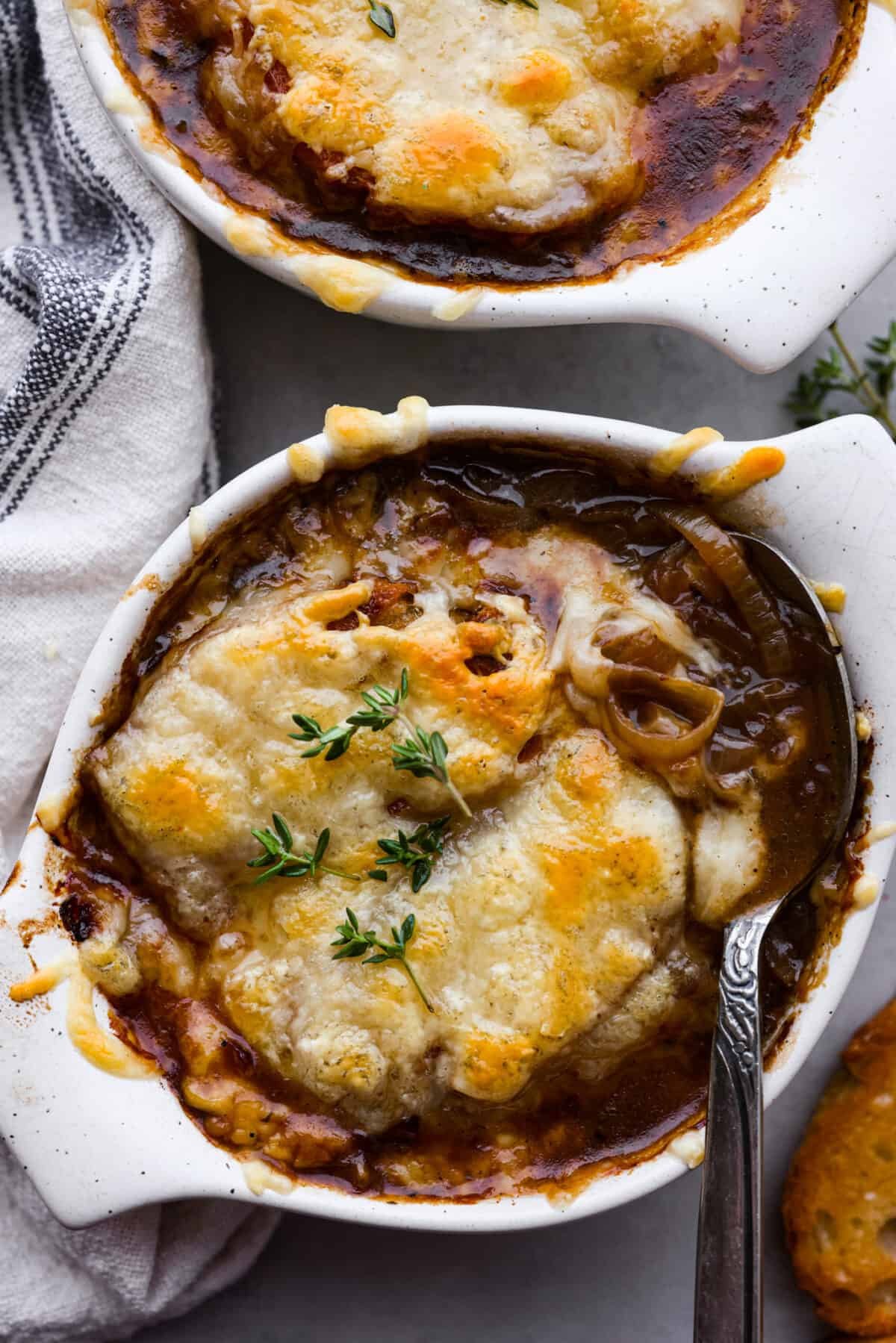 Top-down view of a bowl of French onion soup, topped with melted gruyere cheese.