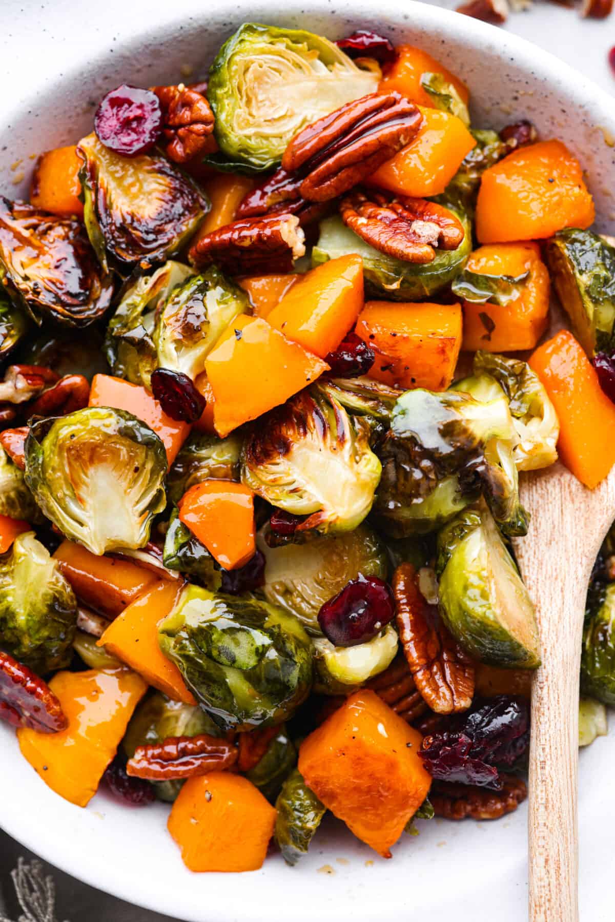 Closeup of maple roasted vegetables in a white baking dish.