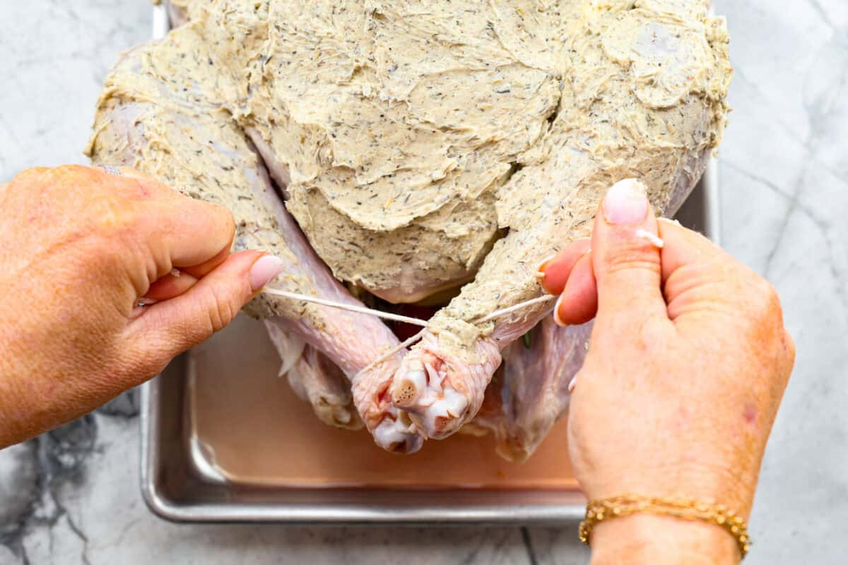 Ninth photo of the legs being tied with twine.