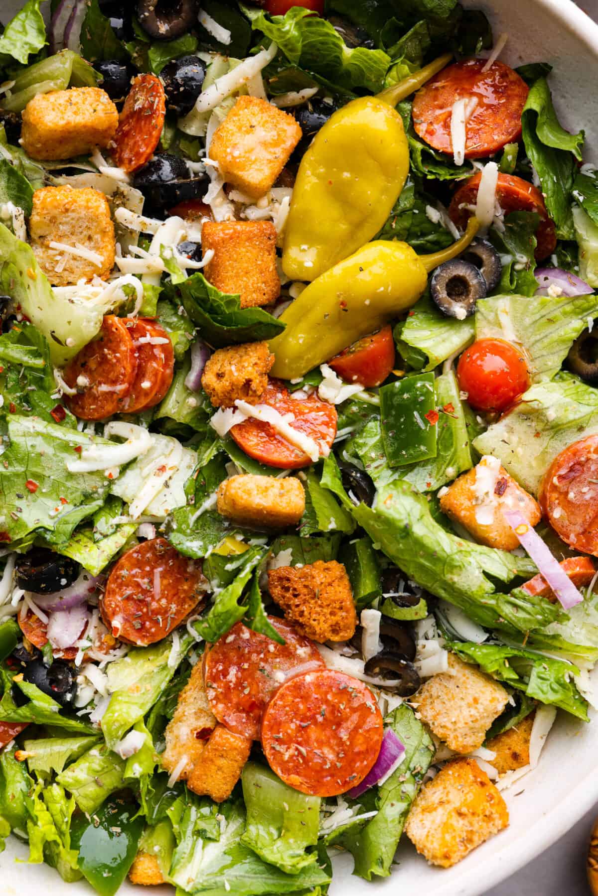 A close up of a finished pizza salad in a large bowl. 