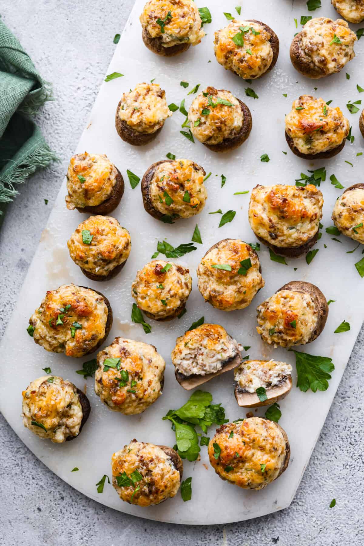 Top-down view of sausage stuffed mushrooms on a serving platter.