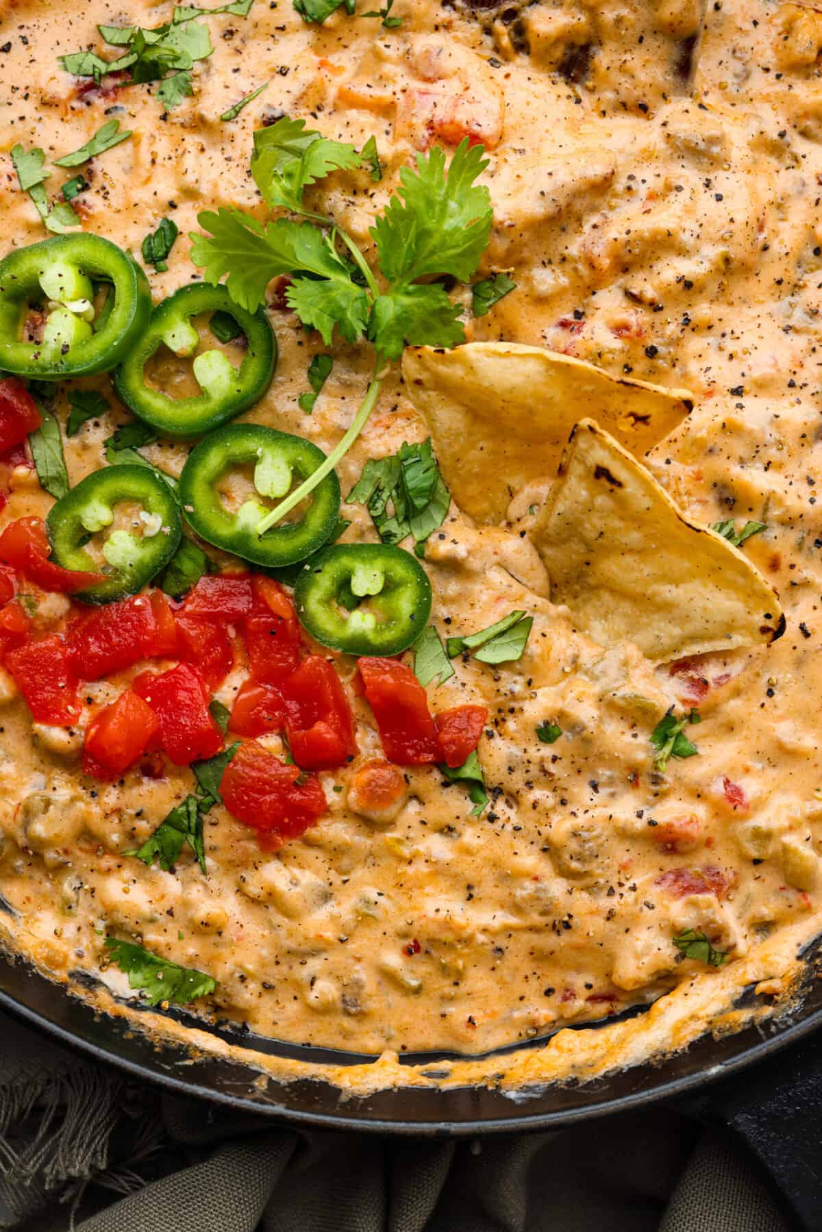 Closeup of sausage dip with tortilla chips in it.