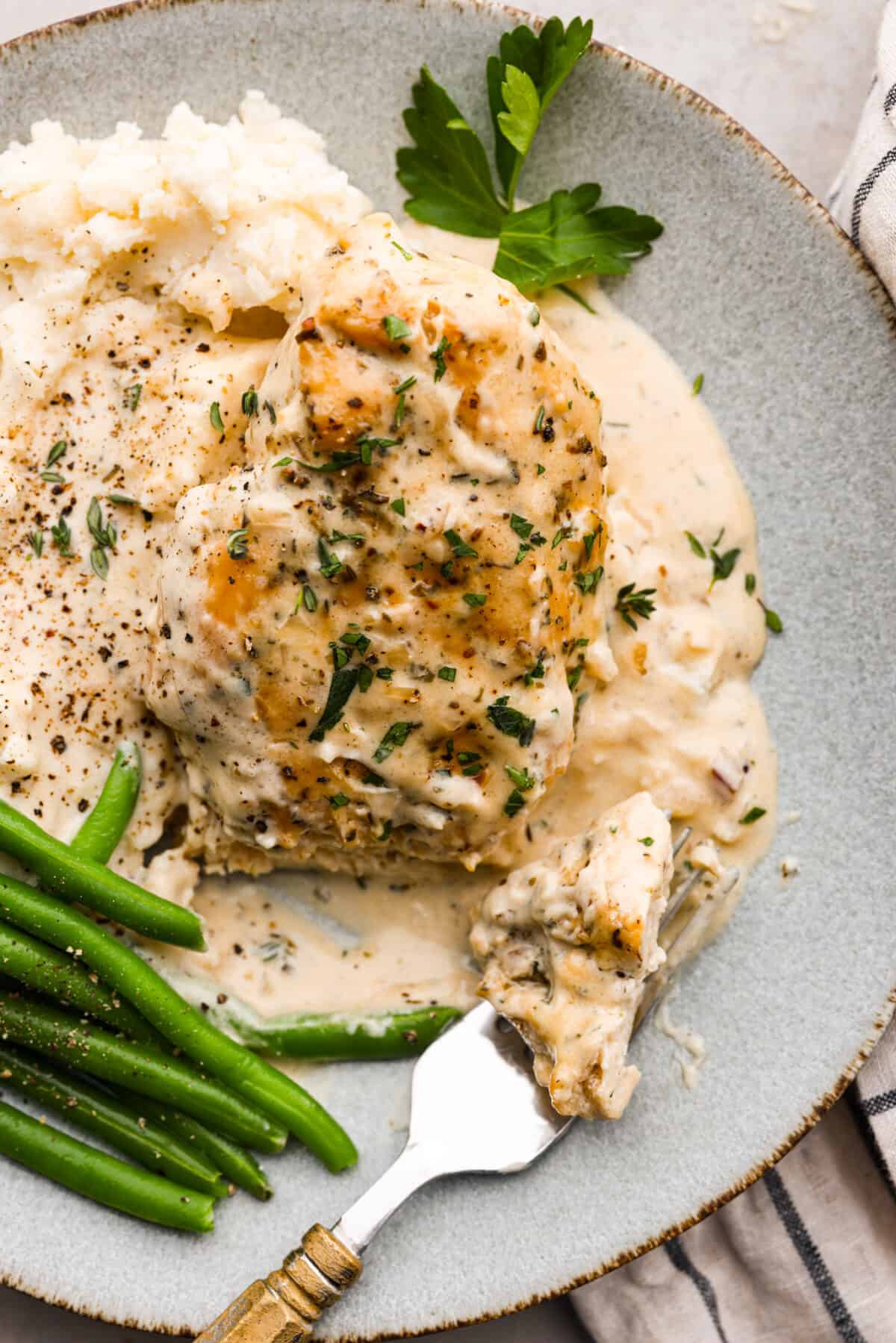 Boursin chicken served on a gray plate with green beans and mashed potatoes.