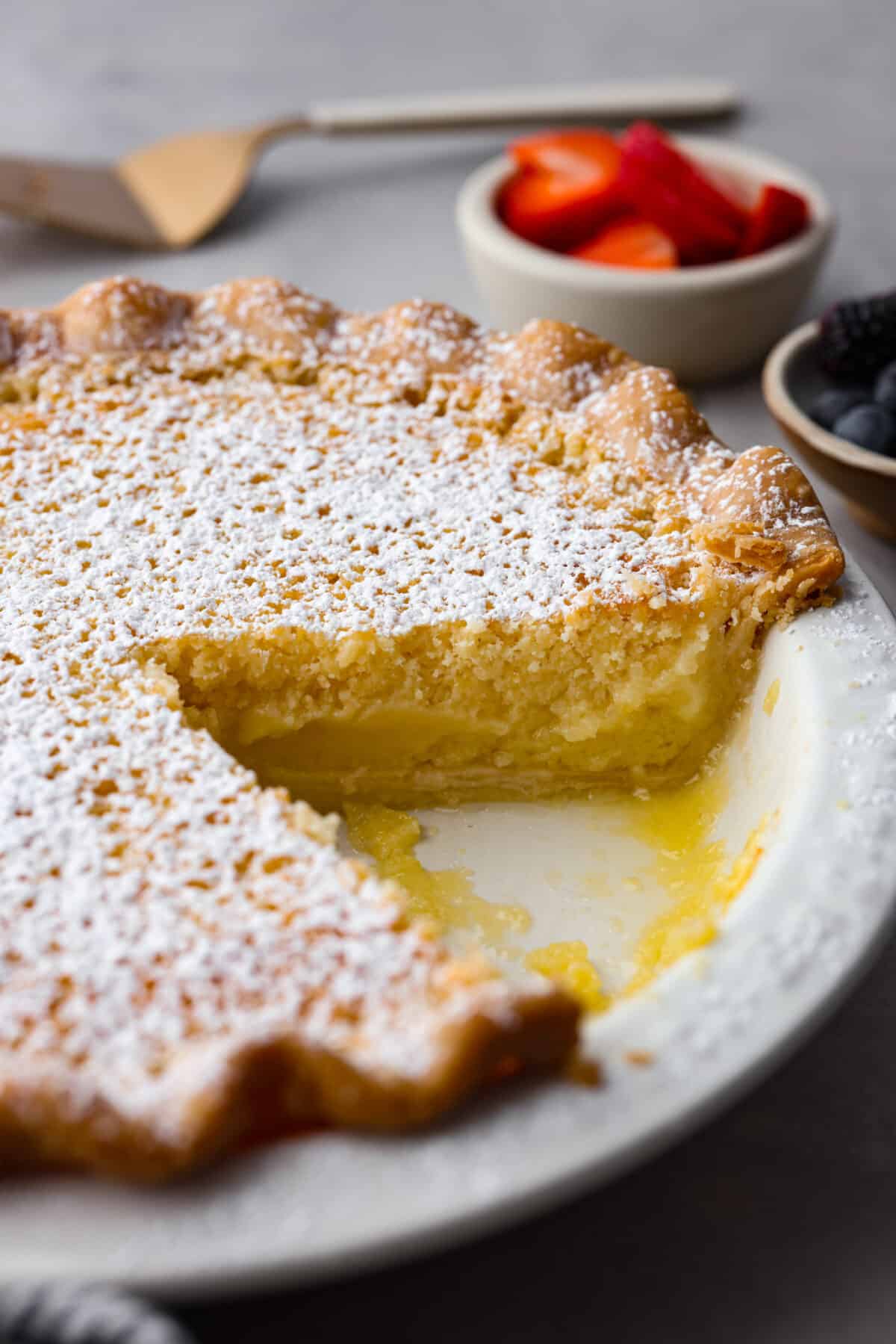Buttermilk pie with a slice cut out of it.