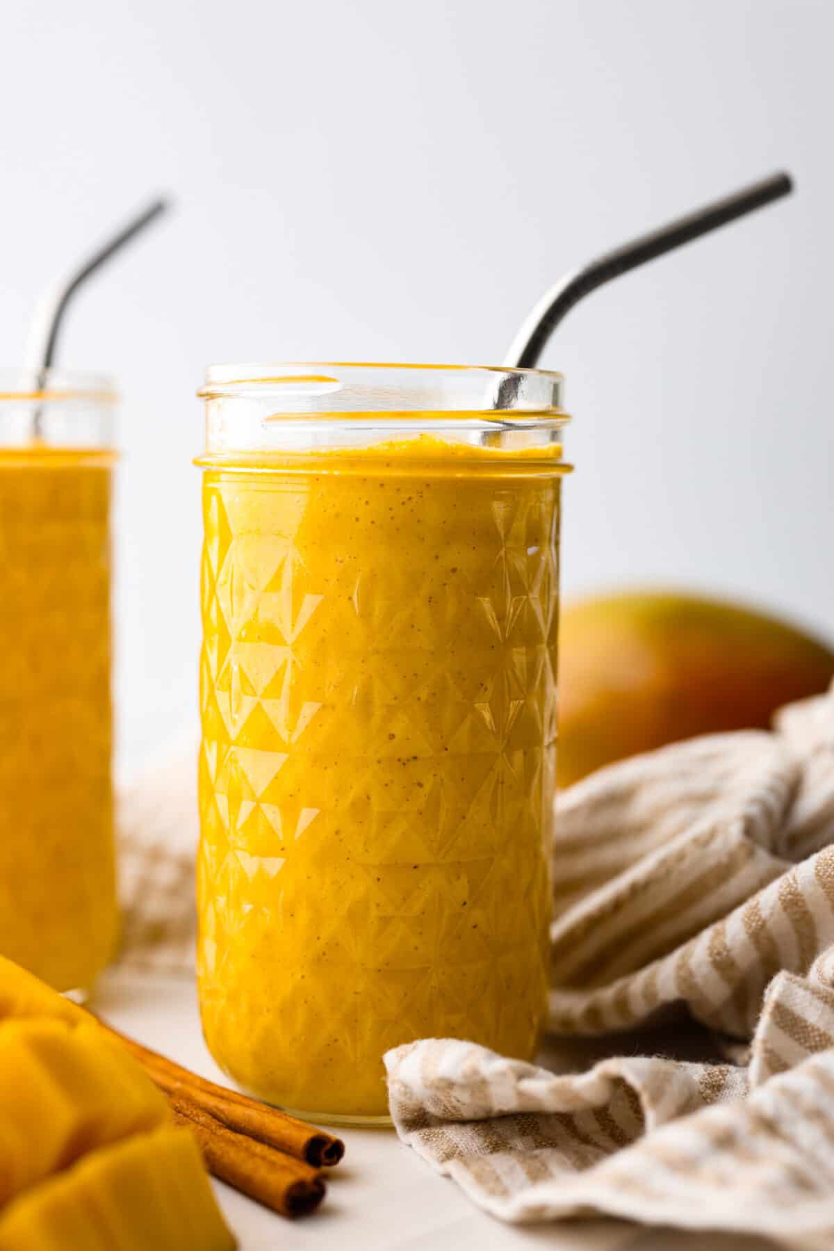 Close side view of the golden milk smoothie in tall glass jars.