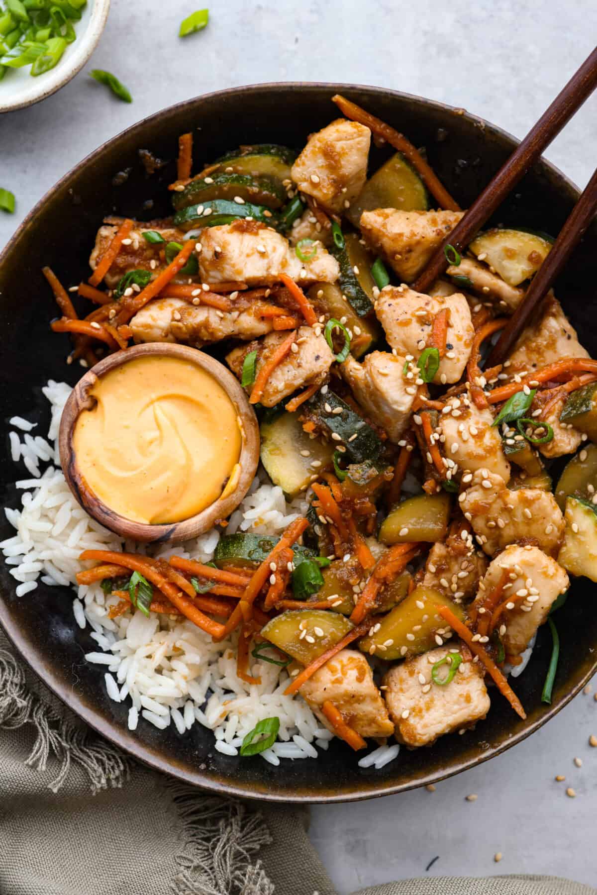 Hibachi chicken on a plate, served with white rice and yum yum sauce.