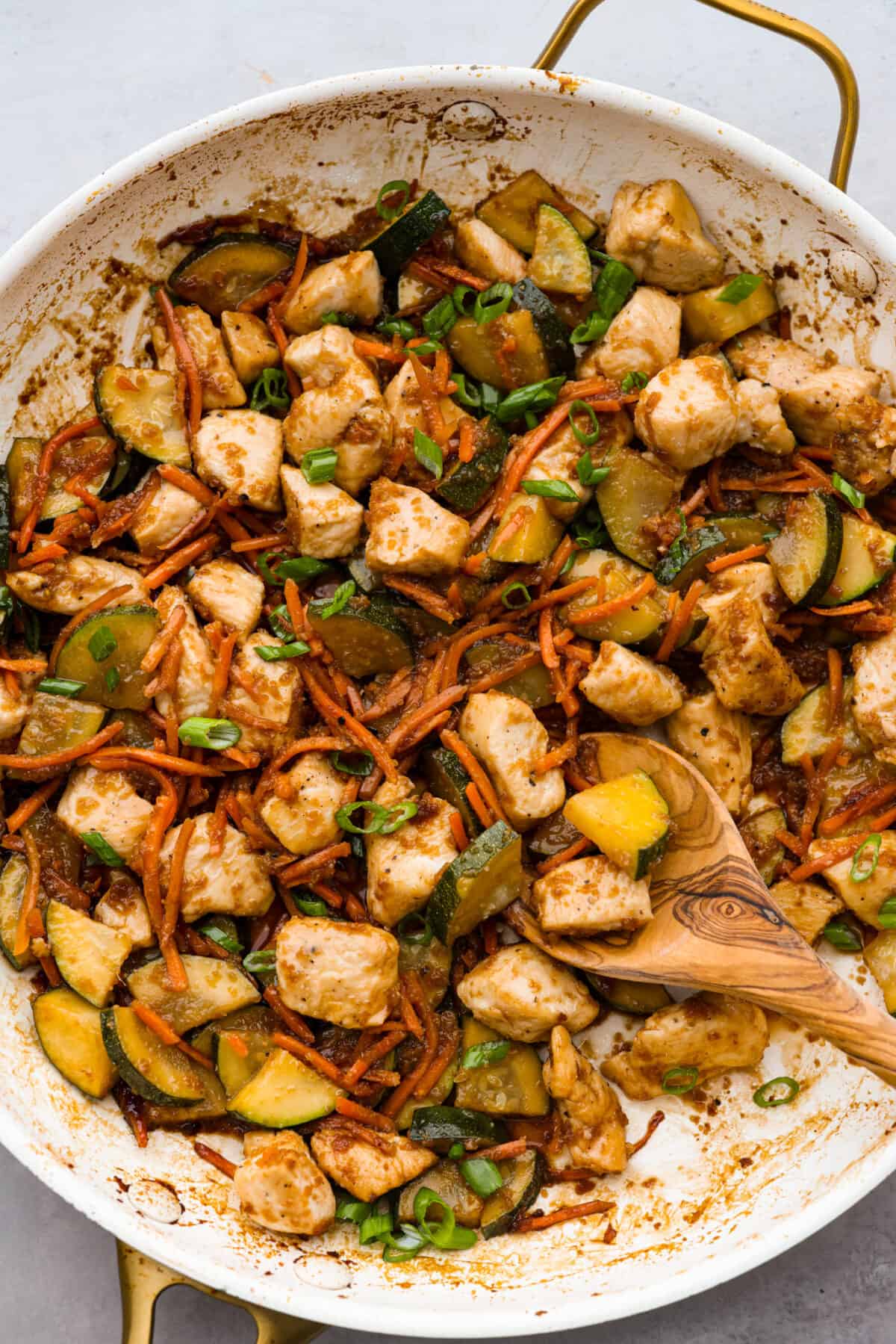 Top-down view of hibachi chicken and cooked vegetables in a skillet.
