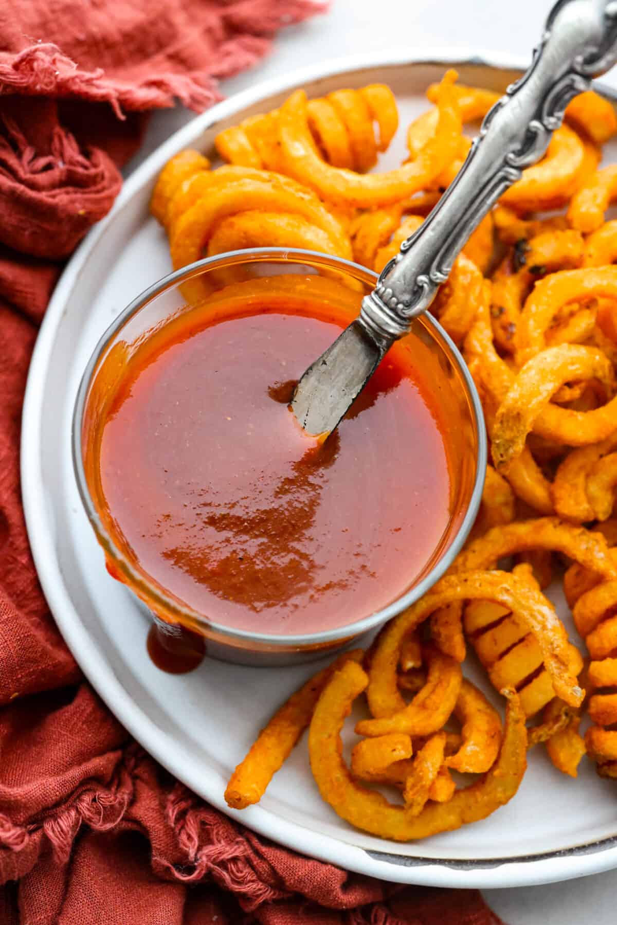 Curly fries served with Arby’s sauce in a small glass bowl.