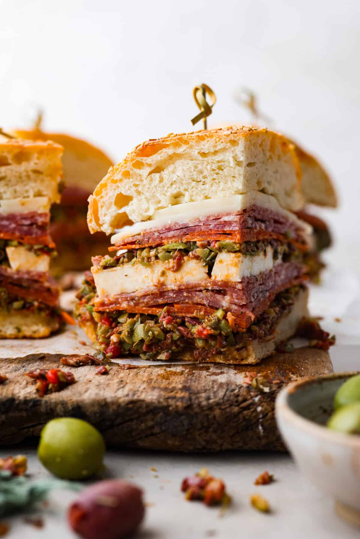 A quarter of a muffuletta sandwich, held together with a toothpick.