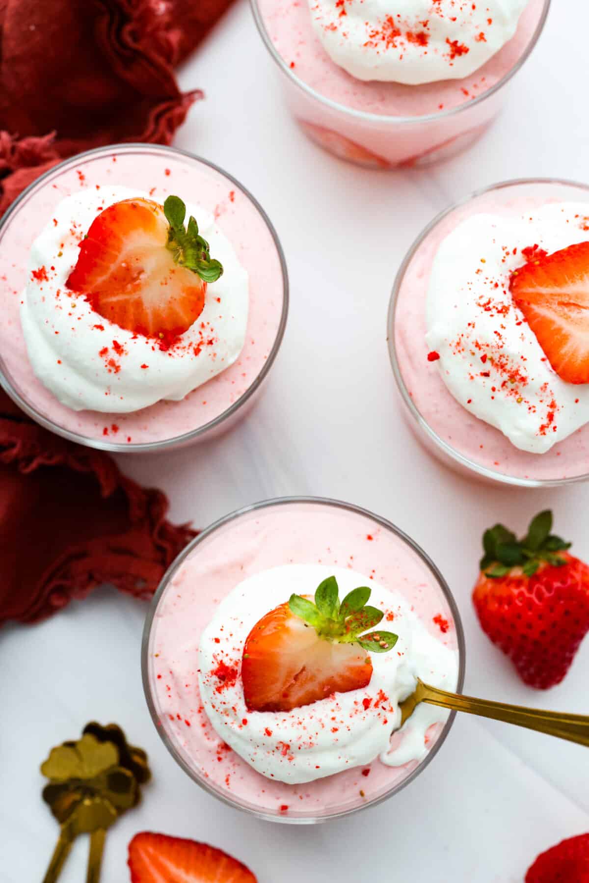 Top-down view of glass cups filled with strawberry mousse.