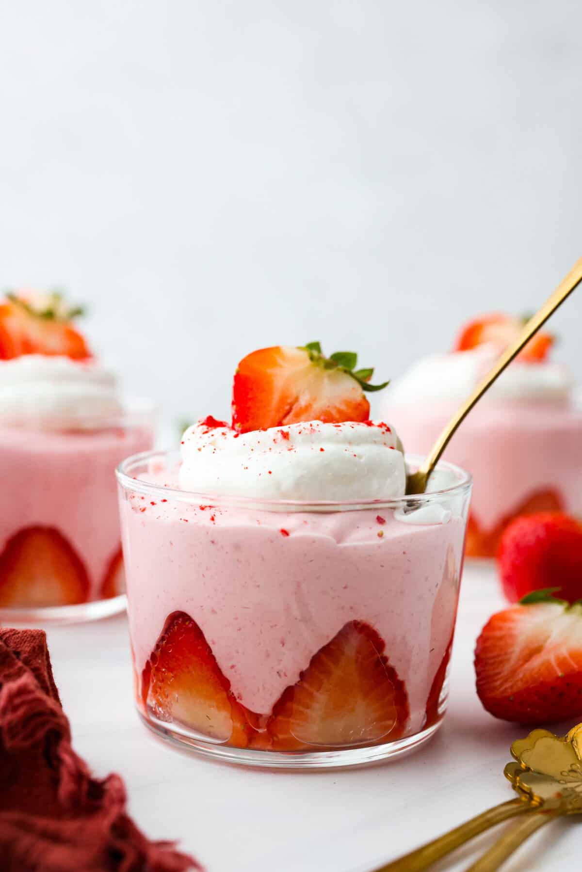 Strawberry mousse in a glass cup lined with sliced strawberries.