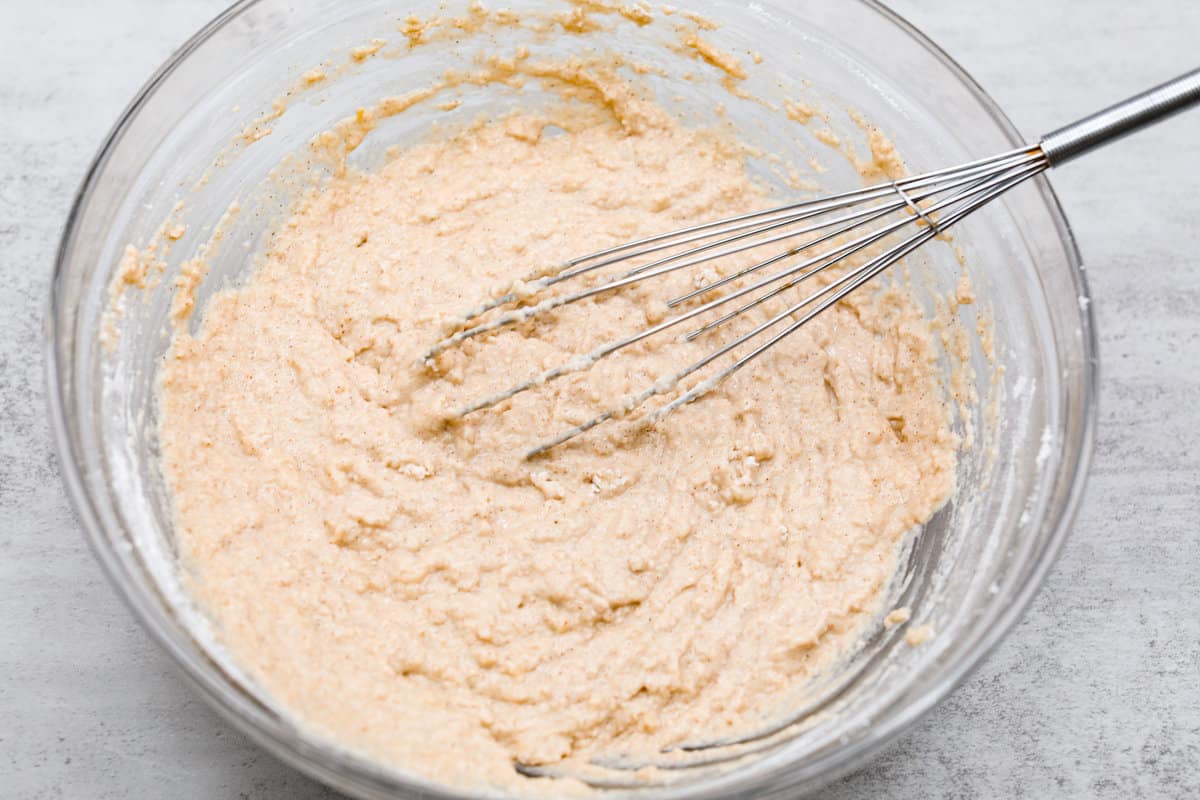 I see a batch of sweet and ultra-moist applesauce muffins in your future! They’re so delicious and made with all-natural sugars. The perfect breakfast, snack, dessert, you name it! Both the dry and wet ingredients being mixed together.