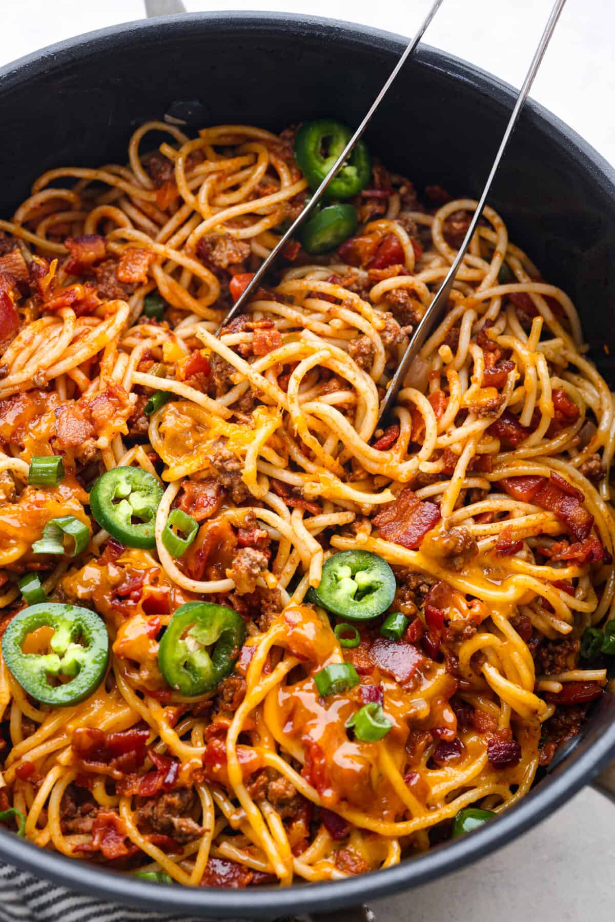 Spaghetti topped with shredded cheese, bacon, and jalapenos.