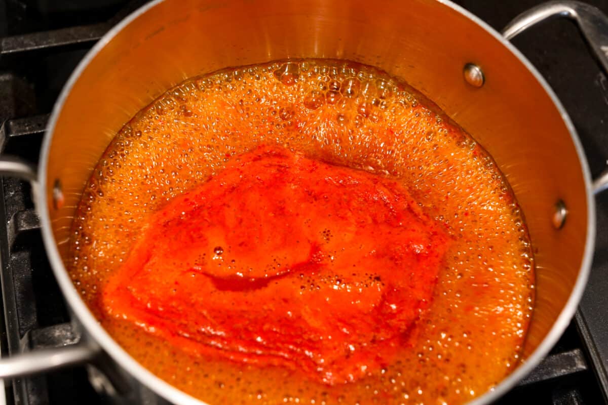 Simmering all of the hot sauce ingredients together.