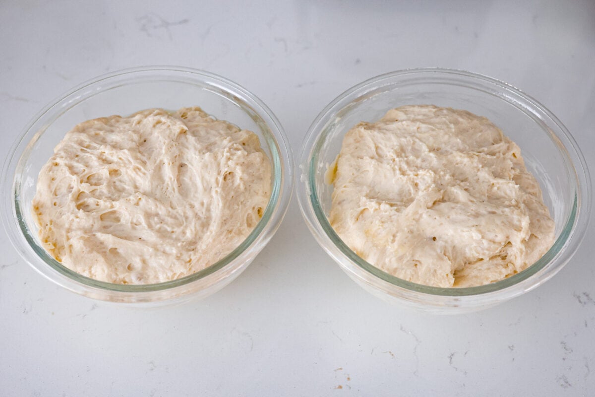 Fourth process photo of the peasant bread dough divided into the prepared bowls.
