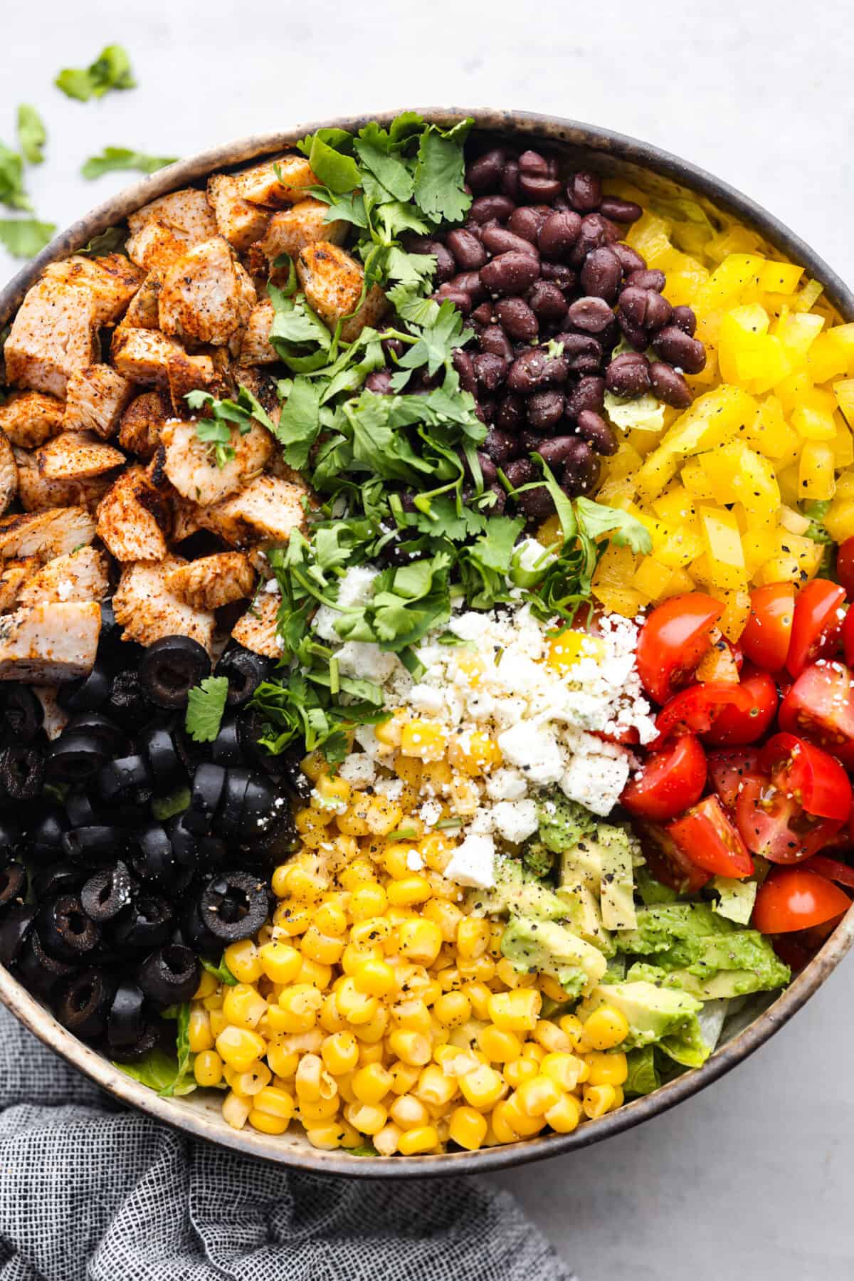A santa fe salad made with vibrant veggies, chicken, and cheese