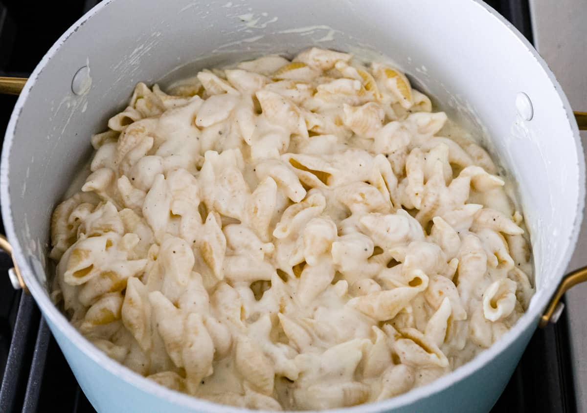 White Cheddar Mac and Cheese is super creamy and filled with rich, decadent flavor. This pasta recipe is the perfect comforting side dish for potlucks, holidays or even weeknight dinners! Stirring to combine