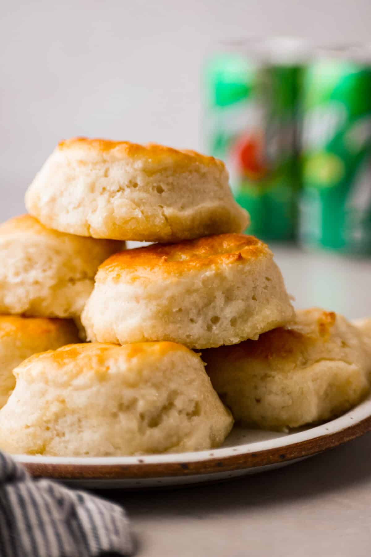 Close view of the 7 up biscuits stacked on a plate with 7 up in the back ground.
