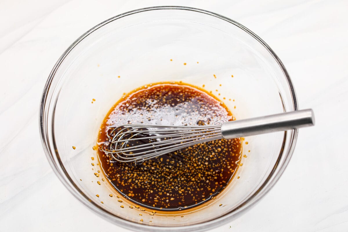 A bowl of marinade with a whisk. 