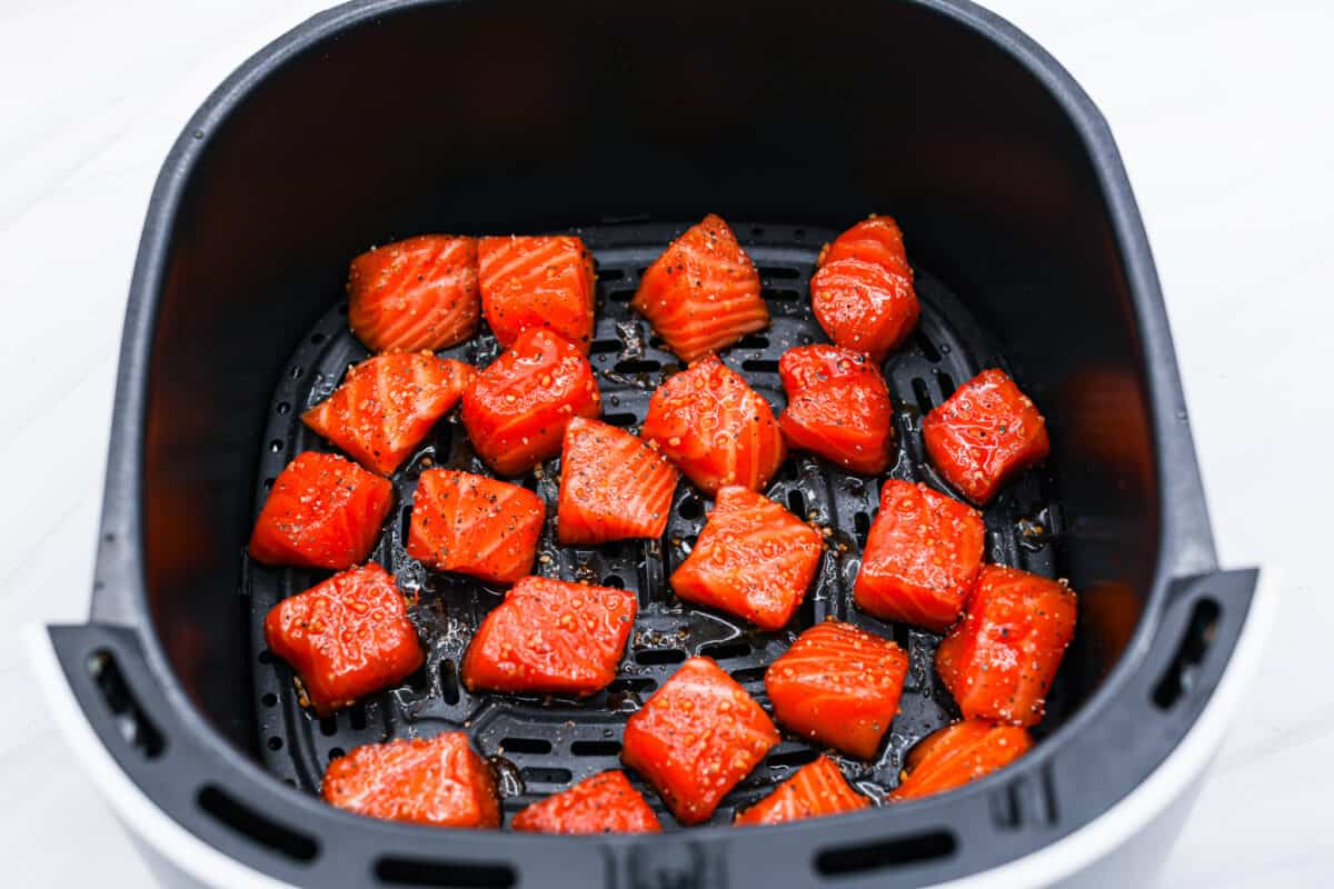 Salmon bites in the air fryer basket ready to cook. 
